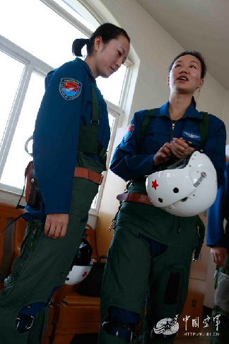 出发前，教员为女飞行员检查飞行装具
