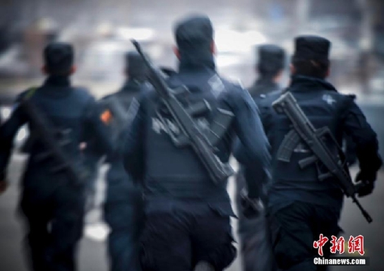 图为特警队员身穿前后插有钢板的防弹衣,携带95式突击步枪一支,总负重达10多公斤,完成3公里武装越野。方涛 摄