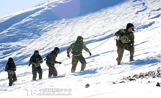 吉林省军区某边防团“天池哨所”官兵用绳子串绑起来,冒着风雪去边境巡逻。(阎江华摄)